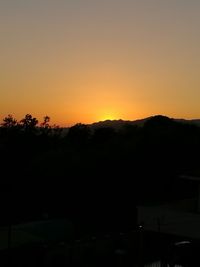 Scenic view of silhouette mountains against orange sky