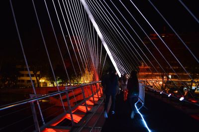 People on suspension bridge at night