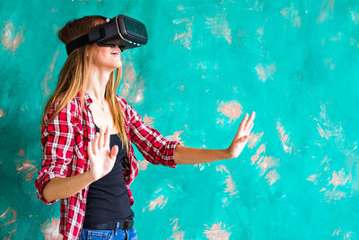 Woman standing outdoors wearing virtual reality headset