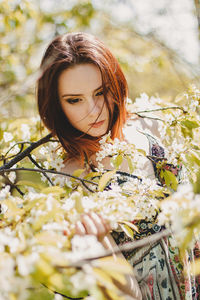 Portrait of young woman with red flower