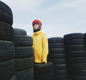 Full length of woman standing by stack against sky during winter