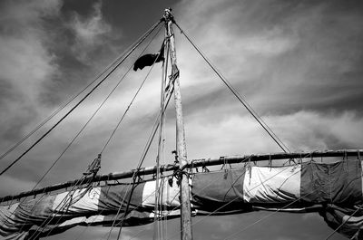 Low angle view of sailboat against cloudy sky