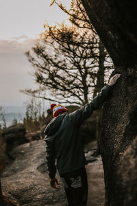 Rear view of man standing against sky during sunset