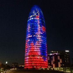 Illuminated modern buildings against sky at night