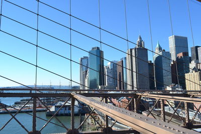 Bridge by buildings against clear sky