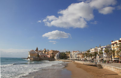 Buildings by sea against sky