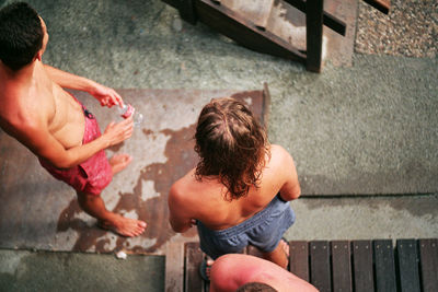 Rear view of shirtless boy lying on staircase