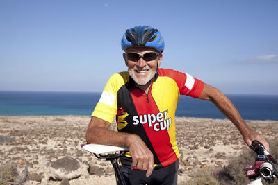 Spain, canary islands, fuerteventura, smiling senior man with mountainbike