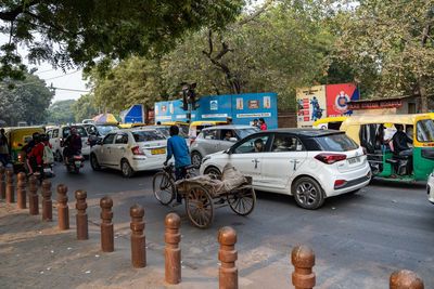 Vehicles on road against trees in city