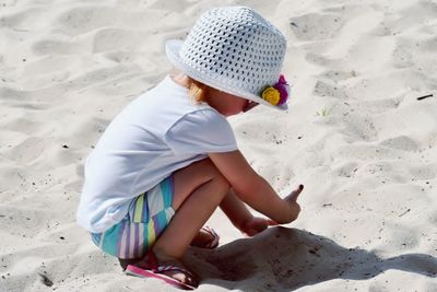 High angle view of girl playing in sand at beach