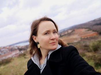 Portrait of smiling young woman against sky