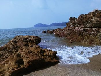 Rocks on beach against sky