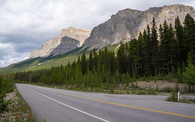 Road by mountains against sky