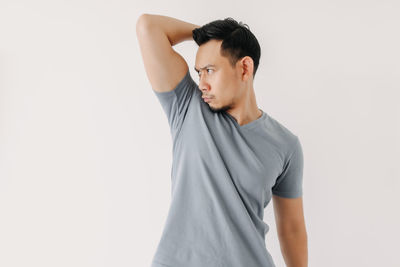 Young man looking away against white background