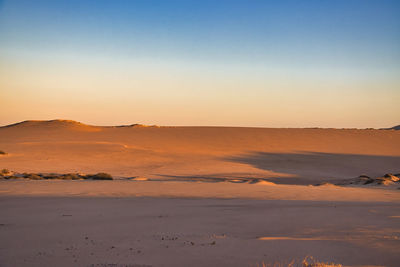 Scenic view of desert against sky during sunset