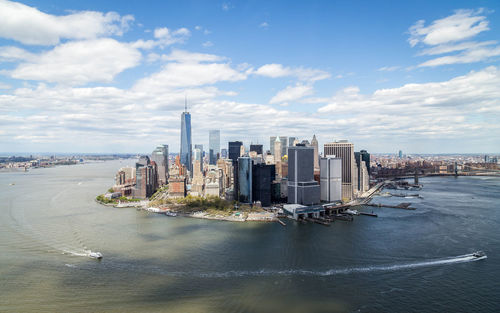 High angle view of east river by modern buildings against cloudy sky