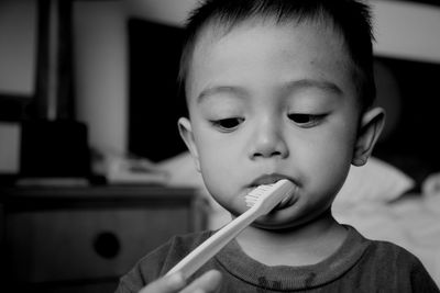 Close-up of cute boy brushing teeth at home