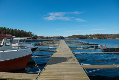 Pier over lake against blue sky