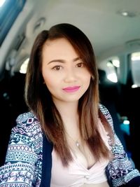 Portrait of beautiful young woman in car