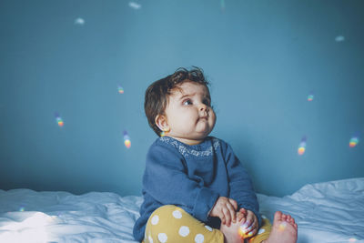 Cute baby girl on bed at home