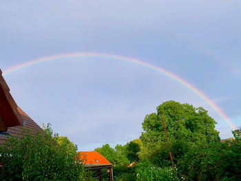 Low angle view of rainbow over building against sky