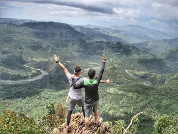 Rear view of friends standing on mountain