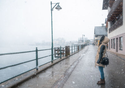 Side view of woman on wet street during winter