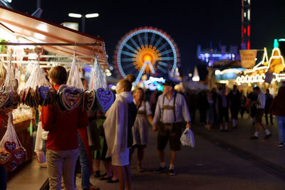 Group of people on the fairground at night