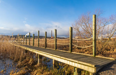 Wooden fence on field against sky