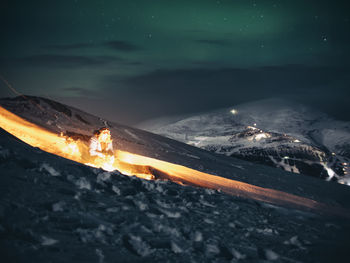 High angle view of illuminated fire against sky at night