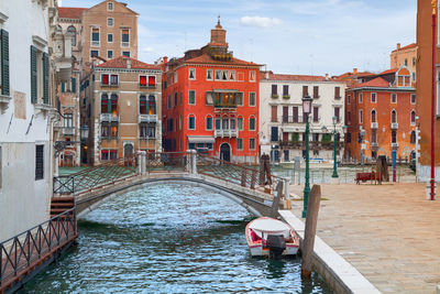 Footbridge over canal against buildings in city