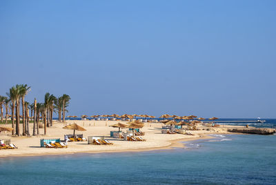 Scenic view of beach against clear blue sky