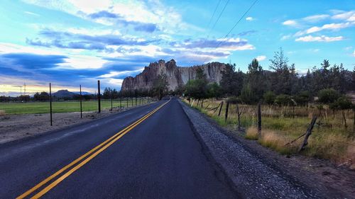 Empty road against cloudy sky