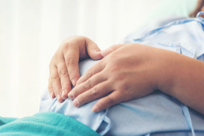 Midsection of woman lying on bed