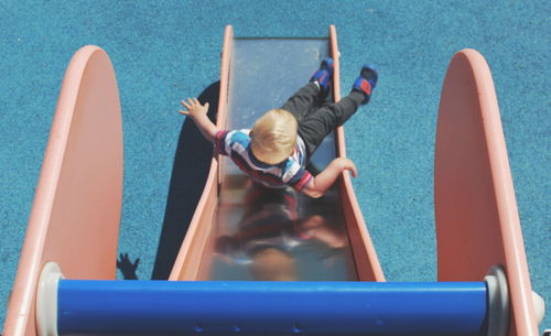 Boy playing on slide at playground