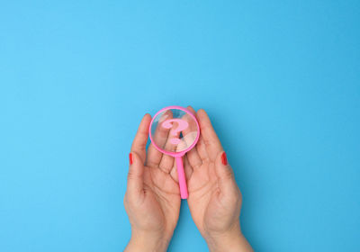 Close-up of woman hand against blue background