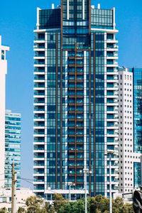 Low angle view of modern buildings against blue sky