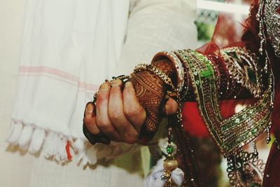 Midsection of couple holding hands