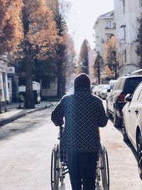 Rear view of man walking on street in city