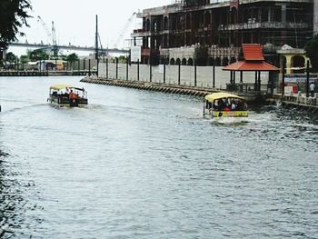 Boats in river with buildings in background