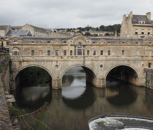 Arch bridge over river against sky