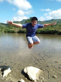Portrait of man levitating over lake