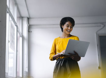 Smiling woman using laptop