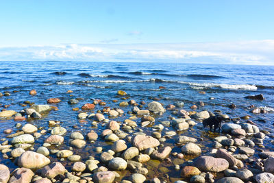 Pebbles on beach against sky