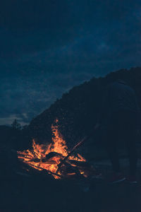 Man with campfire against sky at night