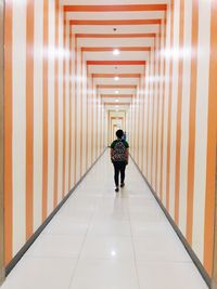 Rear view of men walking in corridor