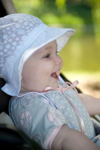 Cute girl wearing hat sitting outdoors