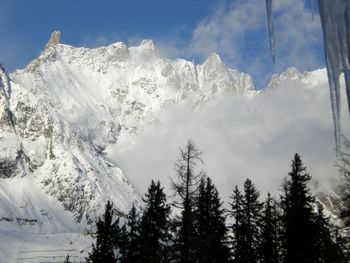 Low angle view of snowcapped mountains against sky