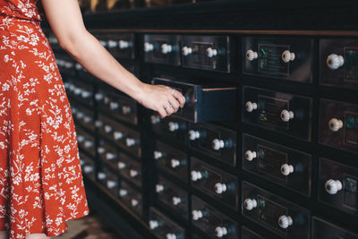 Midsection of woman opening drawer