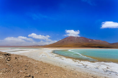 Scenic view of beach against blue sky